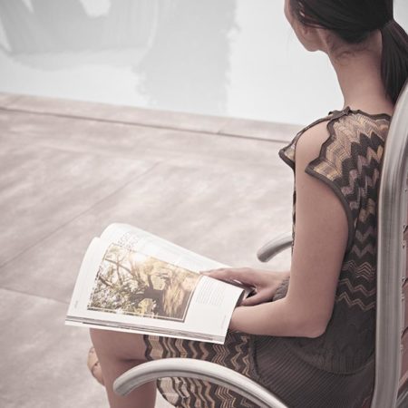 Outdoor Designstuhl Ames mit lesender Frau im Garten